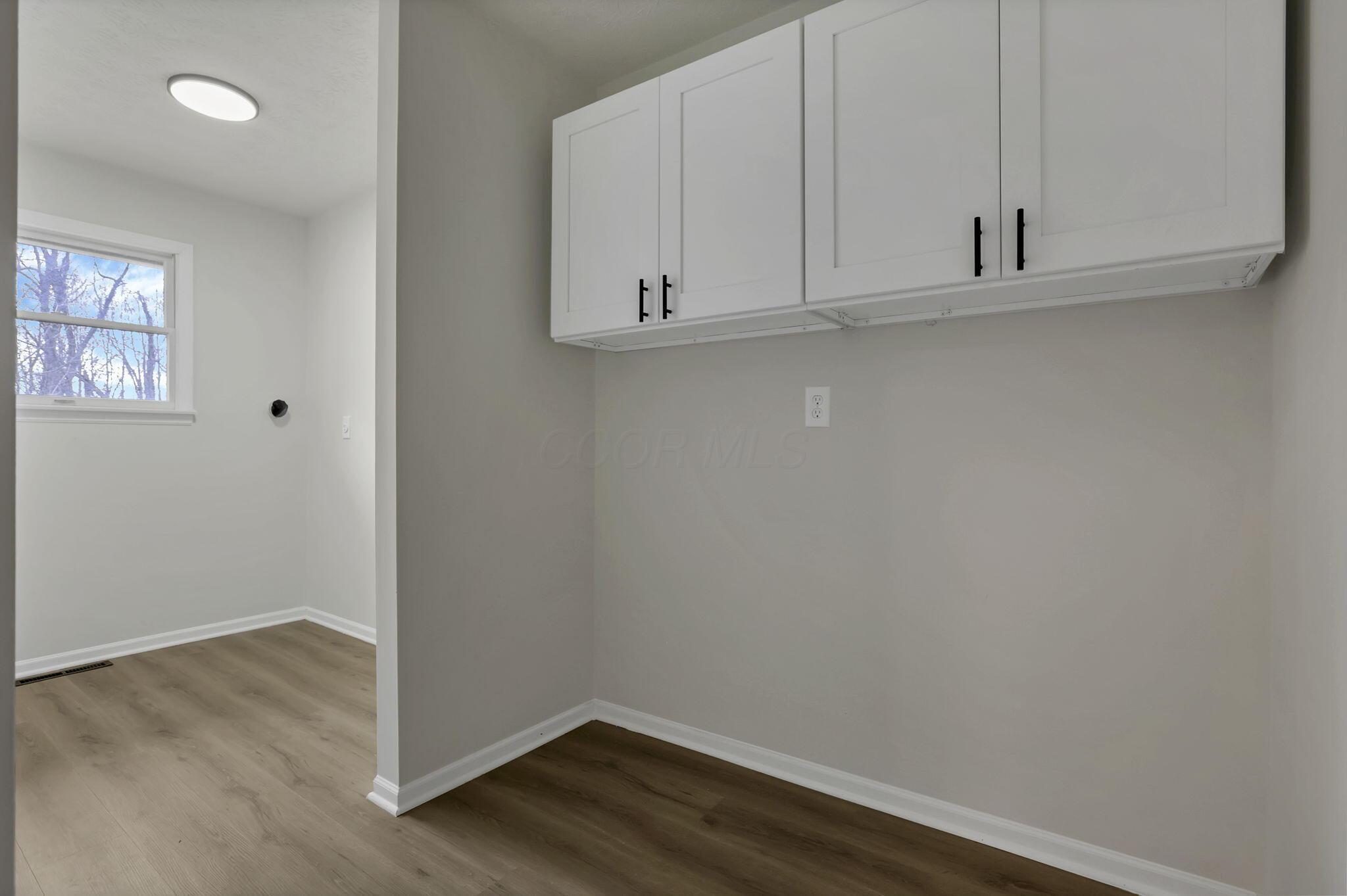 5289 Hazelton-Etna Road Southwest Pataskala, OH 43062 - Photo 22 of 67 Laundry room off the kitchen boasts new cabinetry.