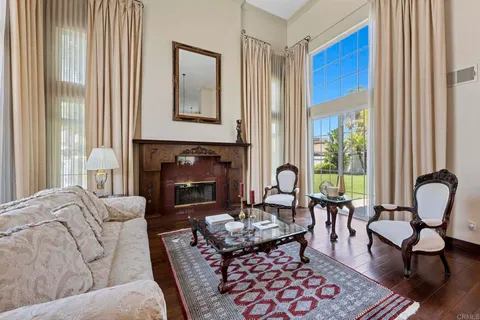 a living room with furniture a fireplace and a chandelier