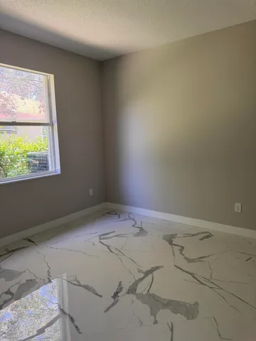 a bathroom with a granite countertop sink a toilet and mirror