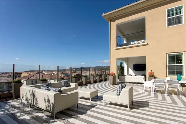 a view of a patio with couches table and chairs with wooden floor