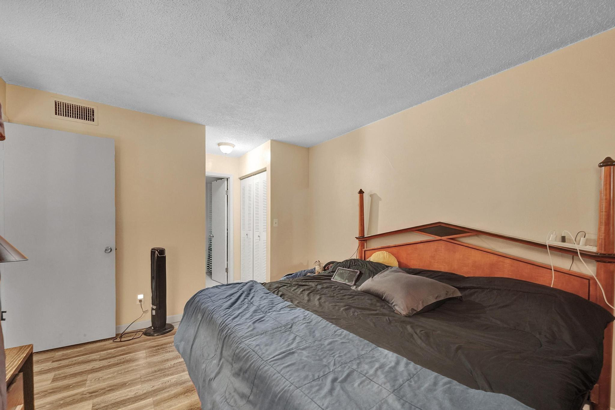 3396 Foxcroft Road, Unit 106 Miramar, FL 33025 - Photo 16 of 24 a bedroom with a bed and a mirror