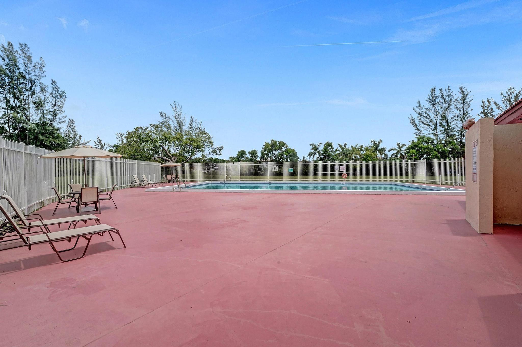 3396 Foxcroft Road, Unit 106 Miramar, FL 33025 - Photo 21 of 24 a view of swimming pool with outdoor seating and yard in back