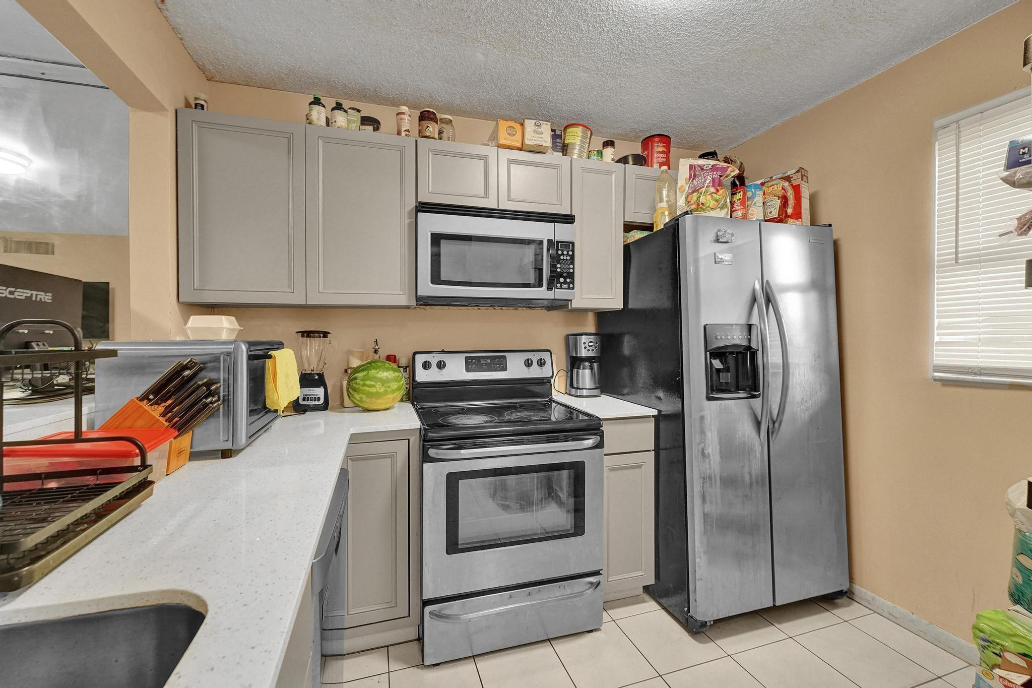3396 Foxcroft Road, Unit 106 Miramar, FL 33025 - Photo 3 of 24 a kitchen with stainless steel appliances granite countertop a refrigerator stove and sink