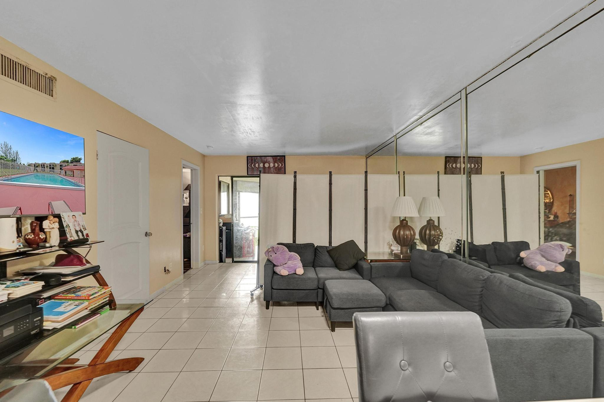 3396 Foxcroft Road, Unit 106 Miramar, FL 33025 - Photo 7 of 24 a living room with furniture and a flat screen tv