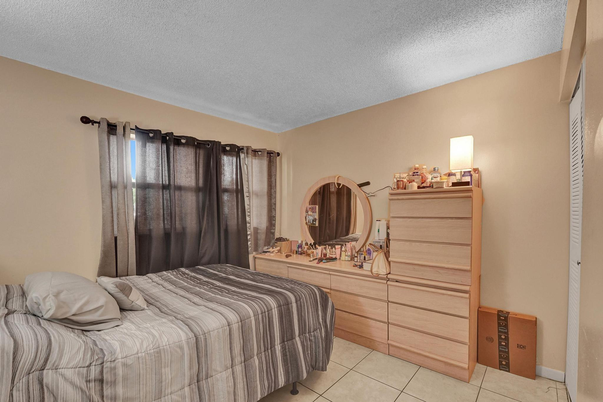 3396 Foxcroft Road, Unit 106 Miramar, FL 33025 - Photo 9 of 24 a bedroom with a bed and dresser