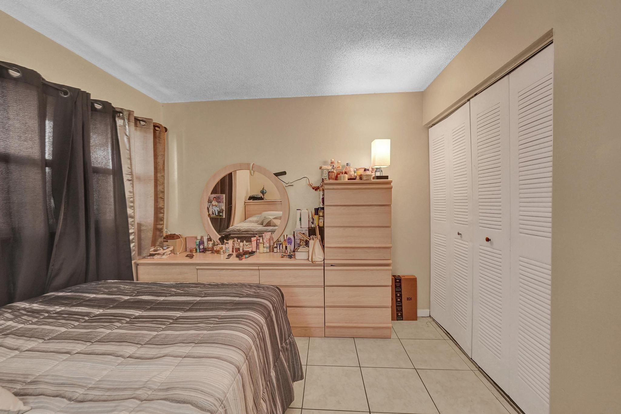3396 Foxcroft Road, Unit 106 Miramar, FL 33025 - Photo 10 of 24 a bedroom with a bed and a dresser