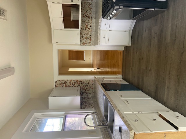 1034 Magnolia Street Lockhart, TX 78644 - Photo 6 of 12 Kitchen with decorative backsplash, dark wood-style flooring, white cabinets, stove, and dishwasher