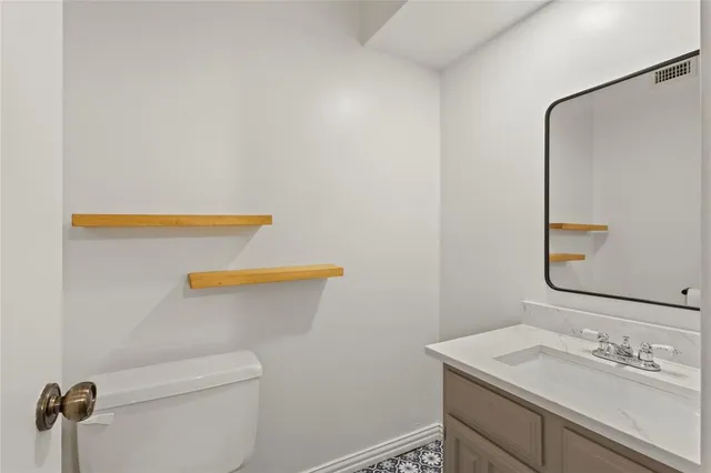 a bathroom with a sink a toilet and mirror