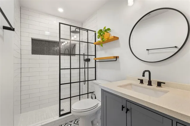a bathroom with a sink a toilet and shower