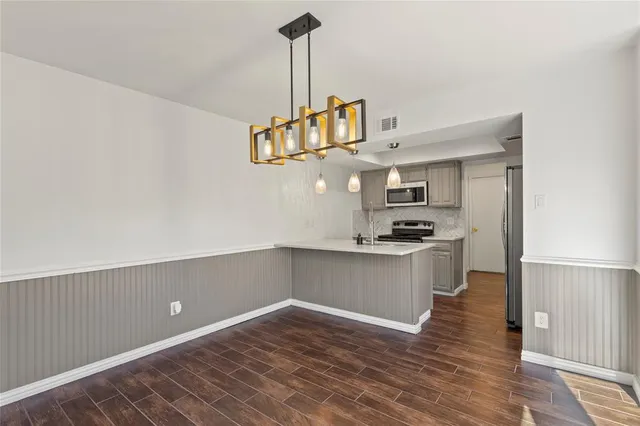 a kitchen with granite countertop a sink cabinets and stainless steel appliances