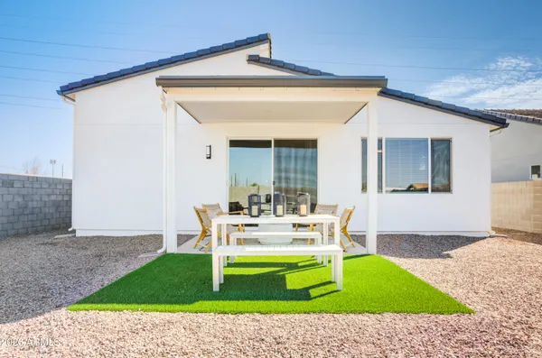 a backyard of a house with wooden floor and outdoor seating