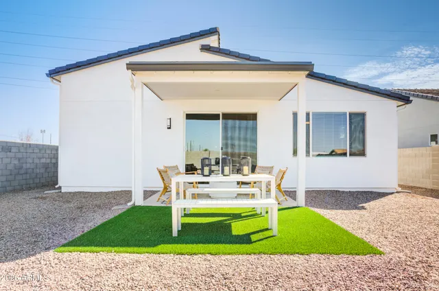 a backyard of a house with wooden floor and outdoor seating