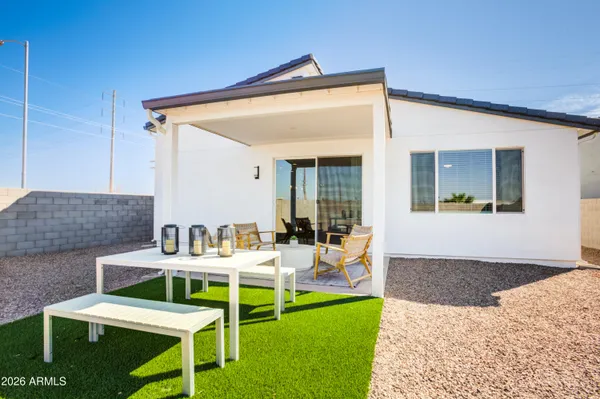 a patio with a table and chairs and potted plants