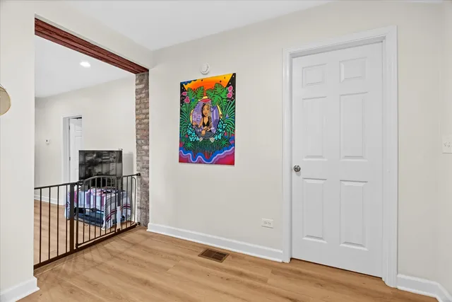 a view of a hallway with wooden floor and entryway