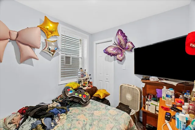 a bedroom with a bed a flat screen tv and dresser
