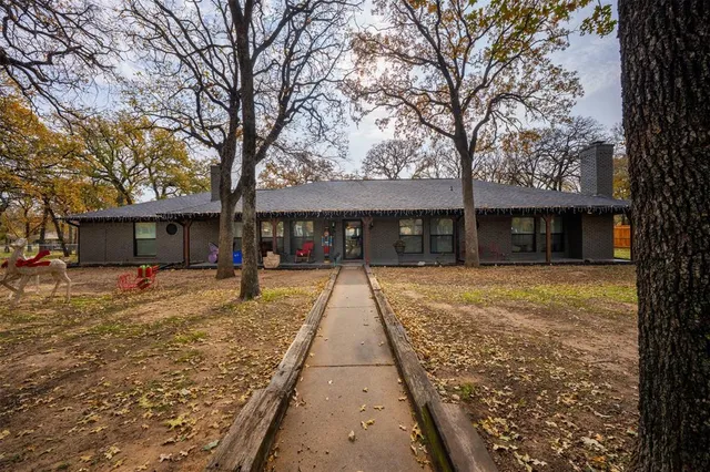 a view of a house with a large tree next to a yard