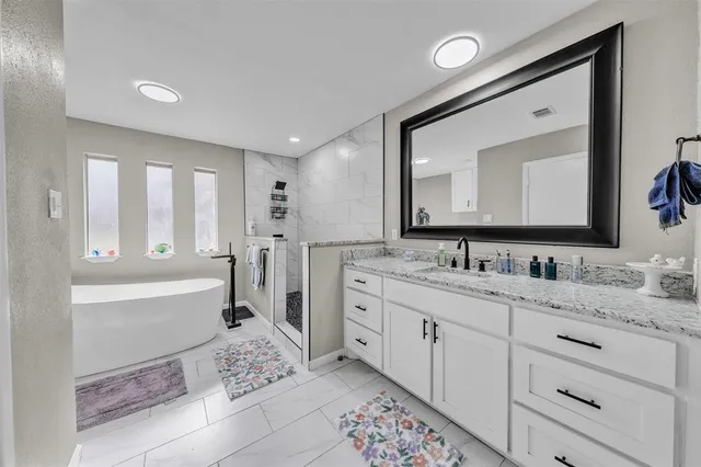 a bathroom with a bathtub sink and a mirror