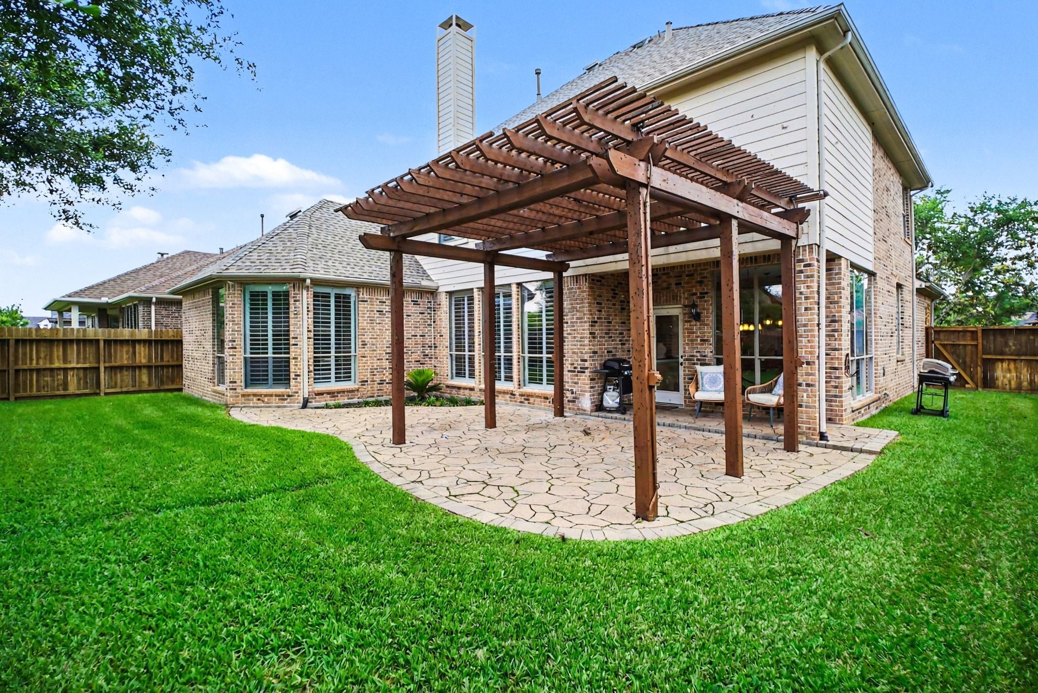 8210 Thunder Ridge Way Missouri City, TX 77459 - Photo 20 of 42 A view of the Pergola and patio off of the kitchen with a view of the side yard that leads to the front.
