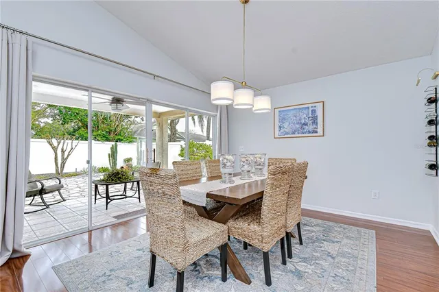 a view of a dining room with furniture a chandelier and wooden floor