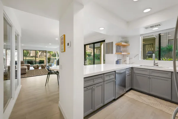a large white kitchen with a large window