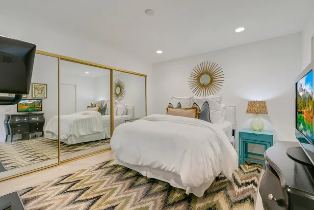 a bedroom with a bed and wooden floor