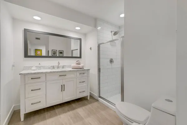 a spacious bathroom with a granite countertop sink mirror and toilet