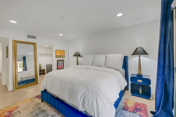 a bedroom with a bed and a mirror