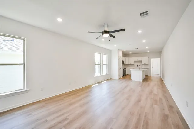a view of empty room with wooden floor and window