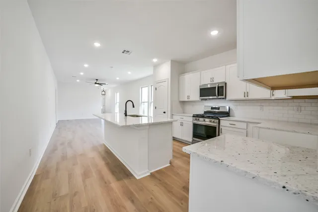 a kitchen with sink a microwave and cabinets