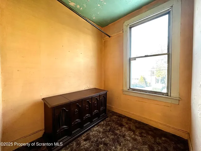 a view of a bedroom with wooden floor and a window