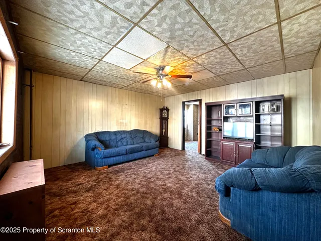 a living room with furniture a ceiling fan and a rug