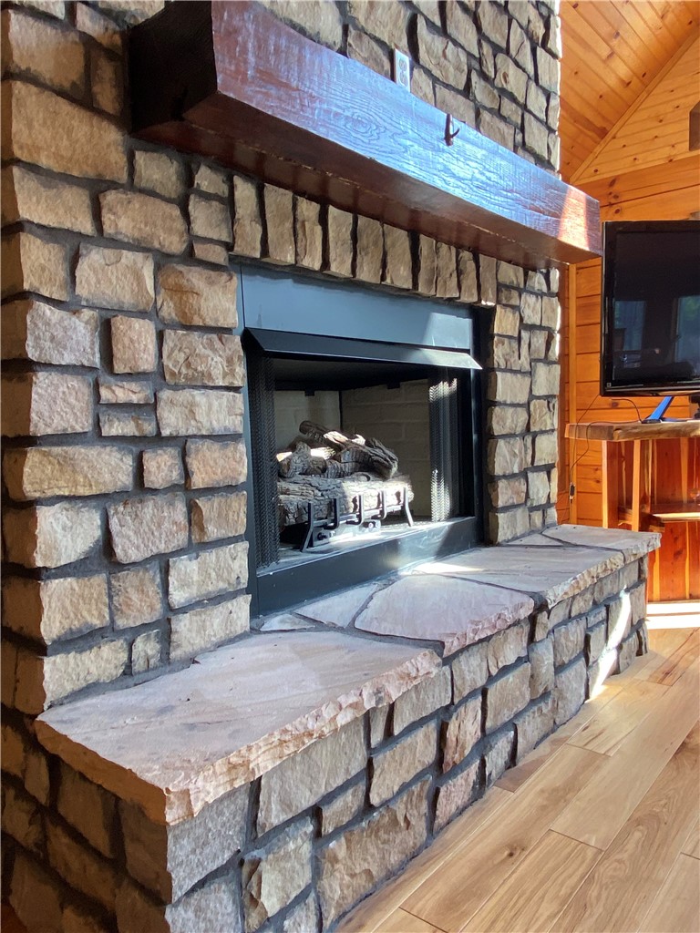 128 McAlister Road West Union, SC 29696 - Photo 10 of 40 A grand stone fireplace anchors the living space, exuding rustic elegance.