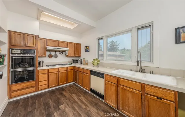 a kitchen with stainless steel appliances granite countertop a stove sink and cabinets