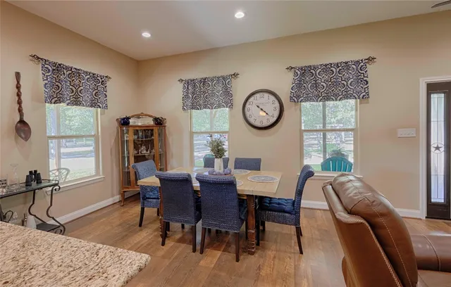 a kitchen with stainless steel appliances granite countertop a sink a stove and a wooden floors