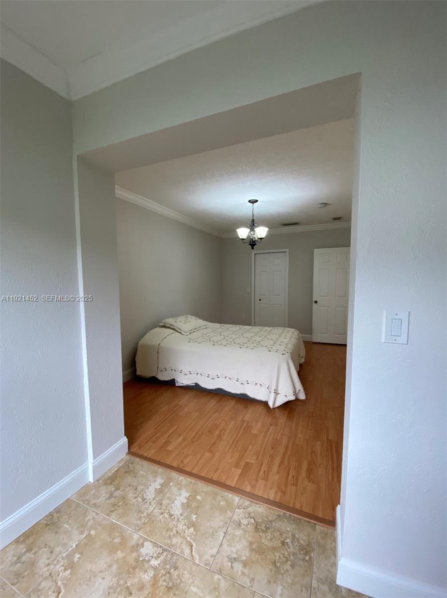 7880 Southwest 14th Terrace Miami, FL 33144 - Photo 13 of 43 a bedroom with a bed and a night stand
