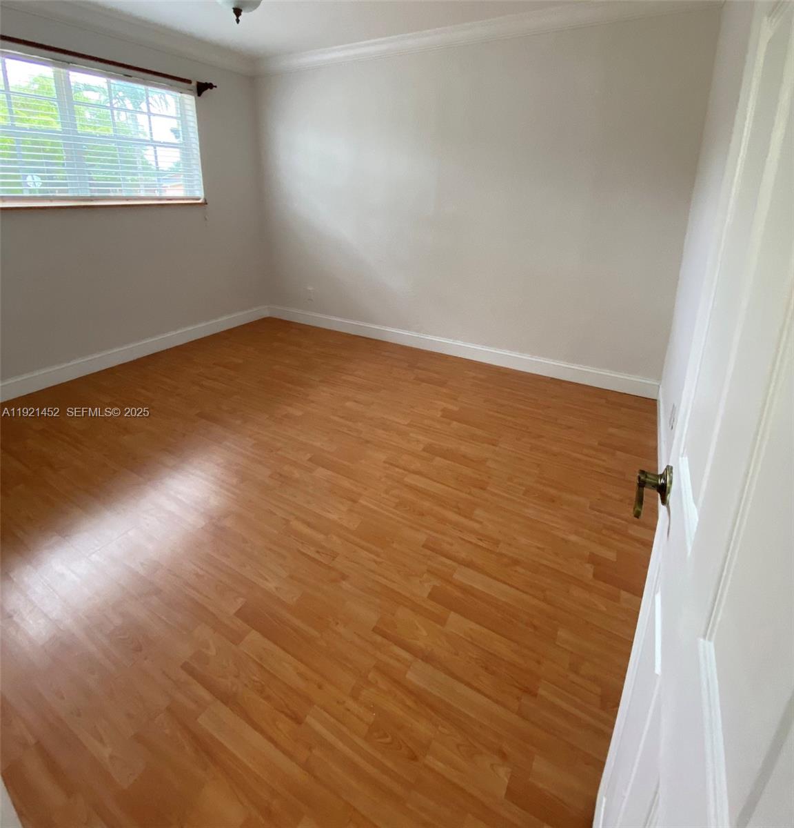 7880 Southwest 14th Terrace Miami, FL 33144 - Photo 20 of 43 an empty room with wooden floor and windows