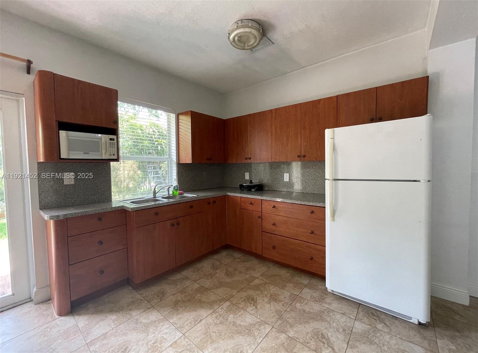 7880 Southwest 14th Terrace Miami, FL 33144 - Photo 30 of 43 a kitchen with granite countertop a refrigerator and a sink