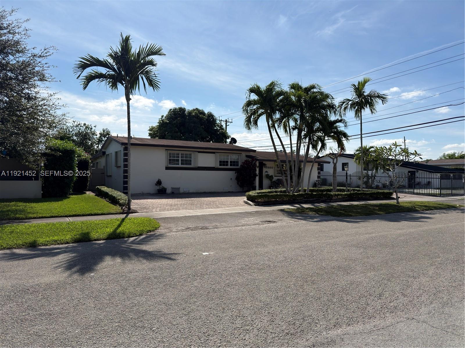 7880 Southwest 14th Terrace Miami, FL 33144 - Photo 4 of 43 a front view of a house with a yard and palm trees
