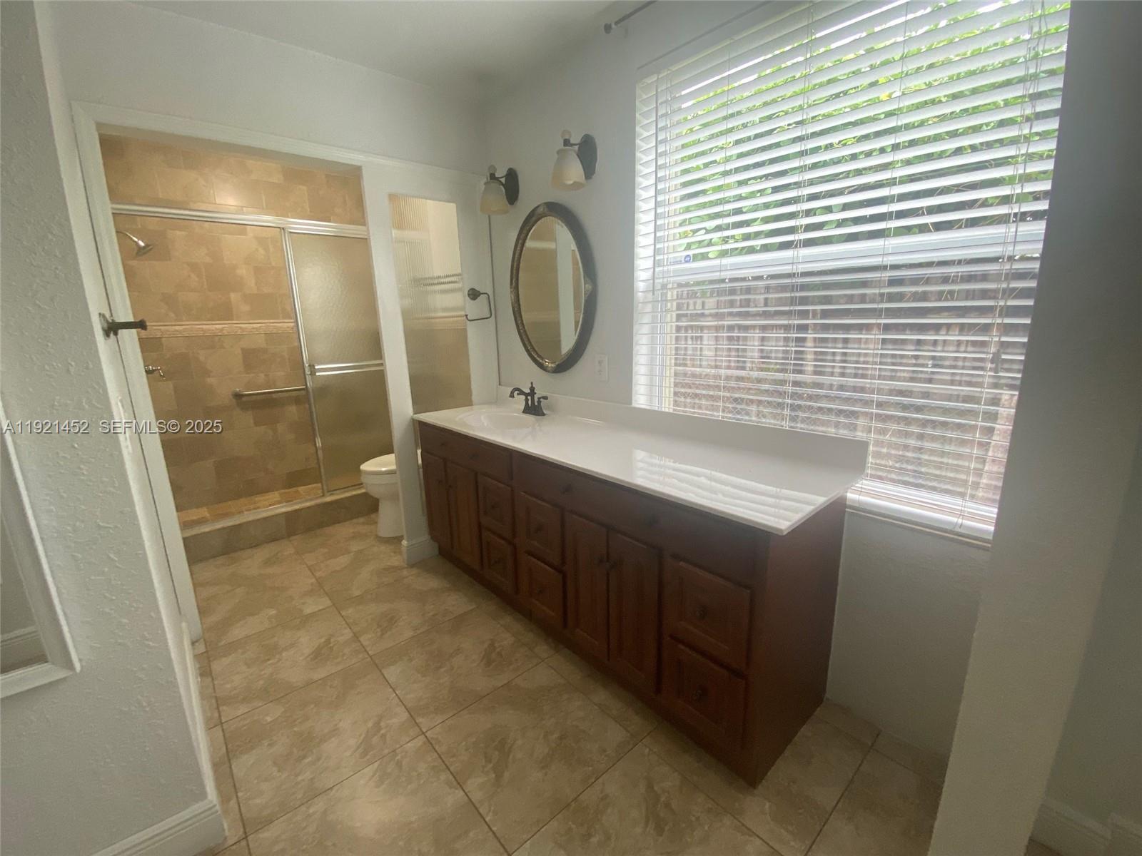 7880 Southwest 14th Terrace Miami, FL 33144 - Photo 42 of 43 a bathroom with a granite countertop sink a mirror and shower