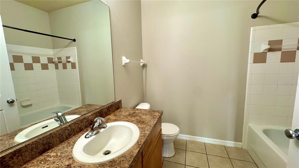 3443 Southwest 24th Street, Unit 101 Gainesville, FL 32608 - Photo 12 of 16 a bathroom with a granite countertop sink toilet and shower