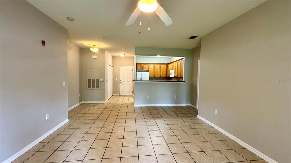 3443 Southwest 24th Street, Unit 101 Gainesville, FL 32608 - Photo 5 of 16 a view of a hallway with wooden floor and a kitchen