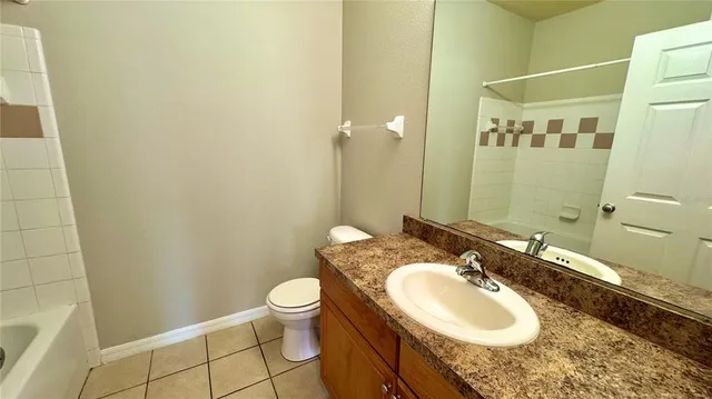 a bathroom with a granite countertop sink toilet and a mirror