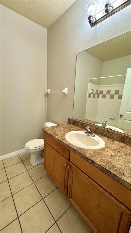 3443 Southwest 24th Street, Unit 101 Gainesville, FL 32608 - Photo 10 of 16 a bathroom with a granite countertop sink a toilet and a mirror