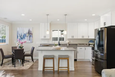 a kitchen with granite countertop white cabinets and white appliances