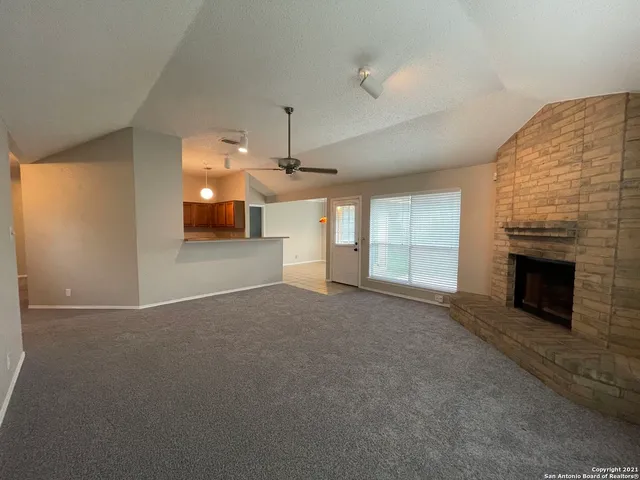 an empty room with a fireplace and window