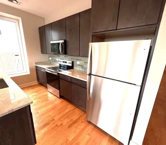 a kitchen with stainless steel appliances a refrigerator sink and microwave