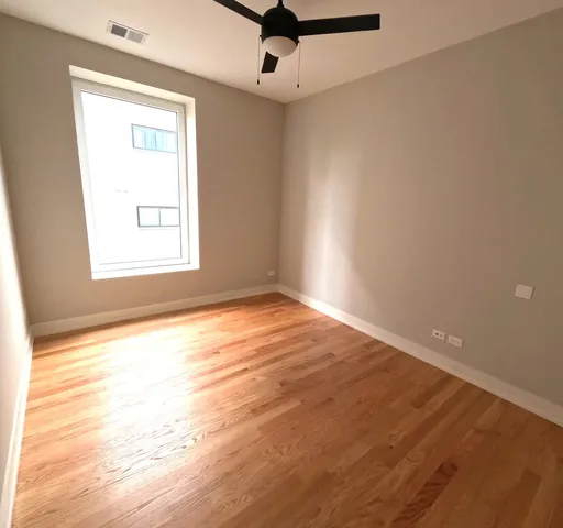 an empty room with a window and a ceiling fan