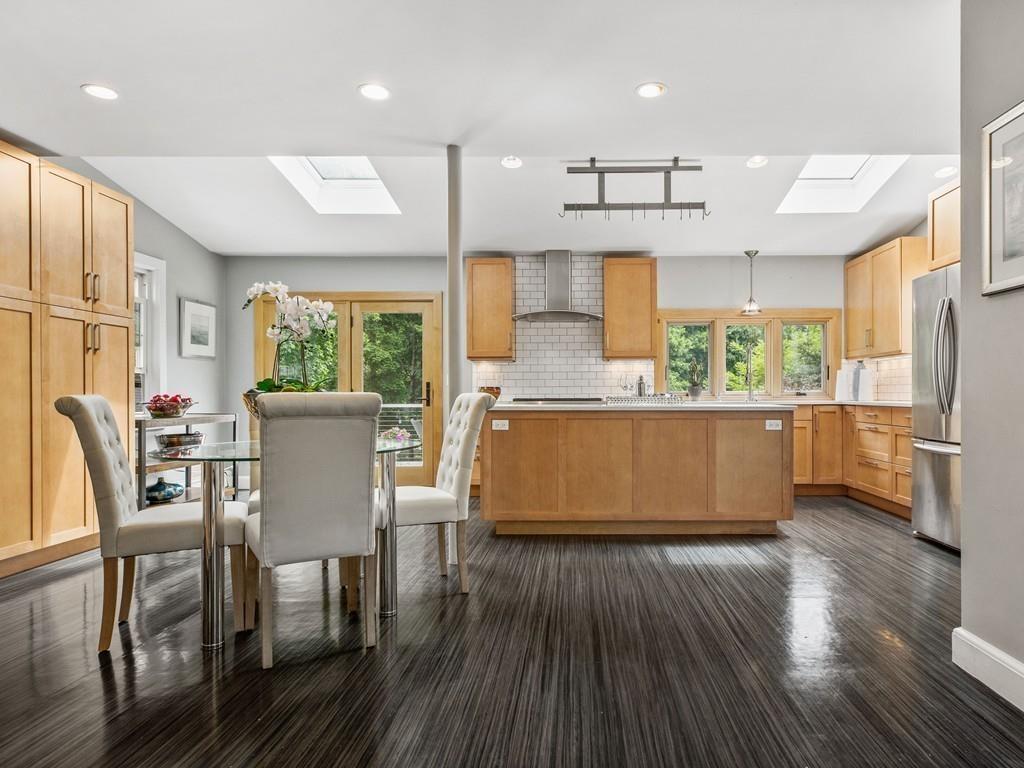 41 Lila Road Boston, MA 02130 - Photo 9 of 39 a kitchen with stainless steel appliances wooden floor dining table and chairs