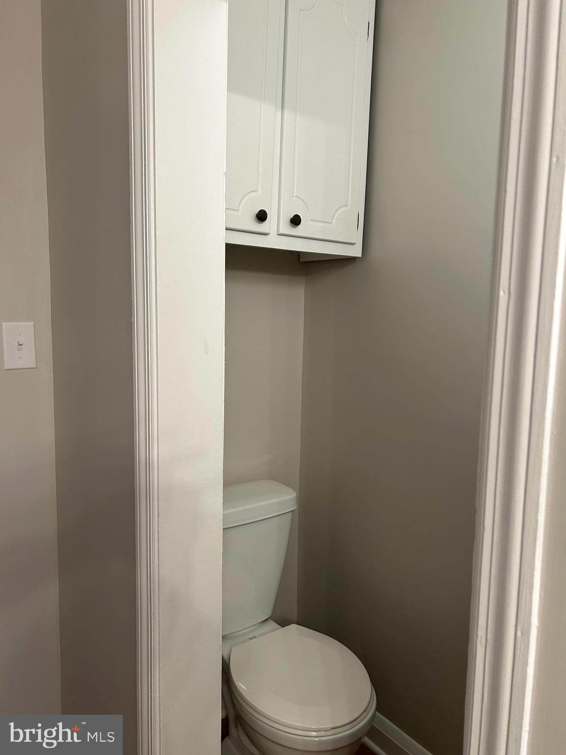 2244 Old Washington Road Westminster, MD 21157 - Photo 22 of 60 a white toilet sitting next to a wooden cabinet