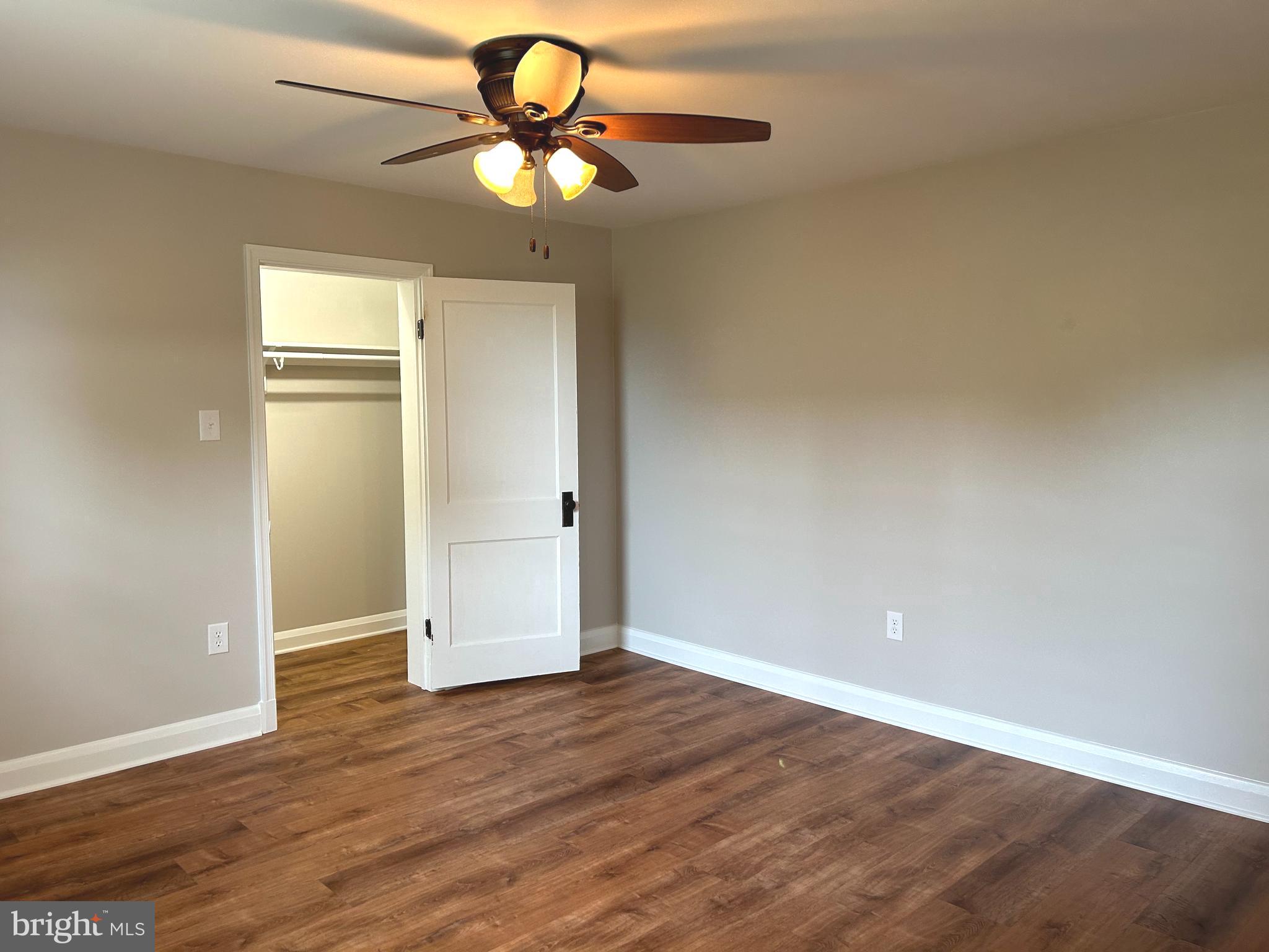 2244 Old Washington Road Westminster, MD 21157 - Photo 24 of 60 an empty room with wooden floor chandelier fan and windows